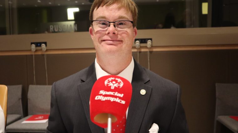 Athlete smiles at camera with a red microphone in front of them