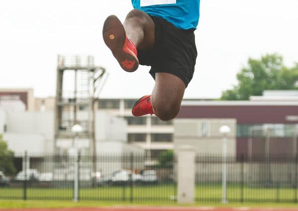 An athlete soars through the air during a long jump competition