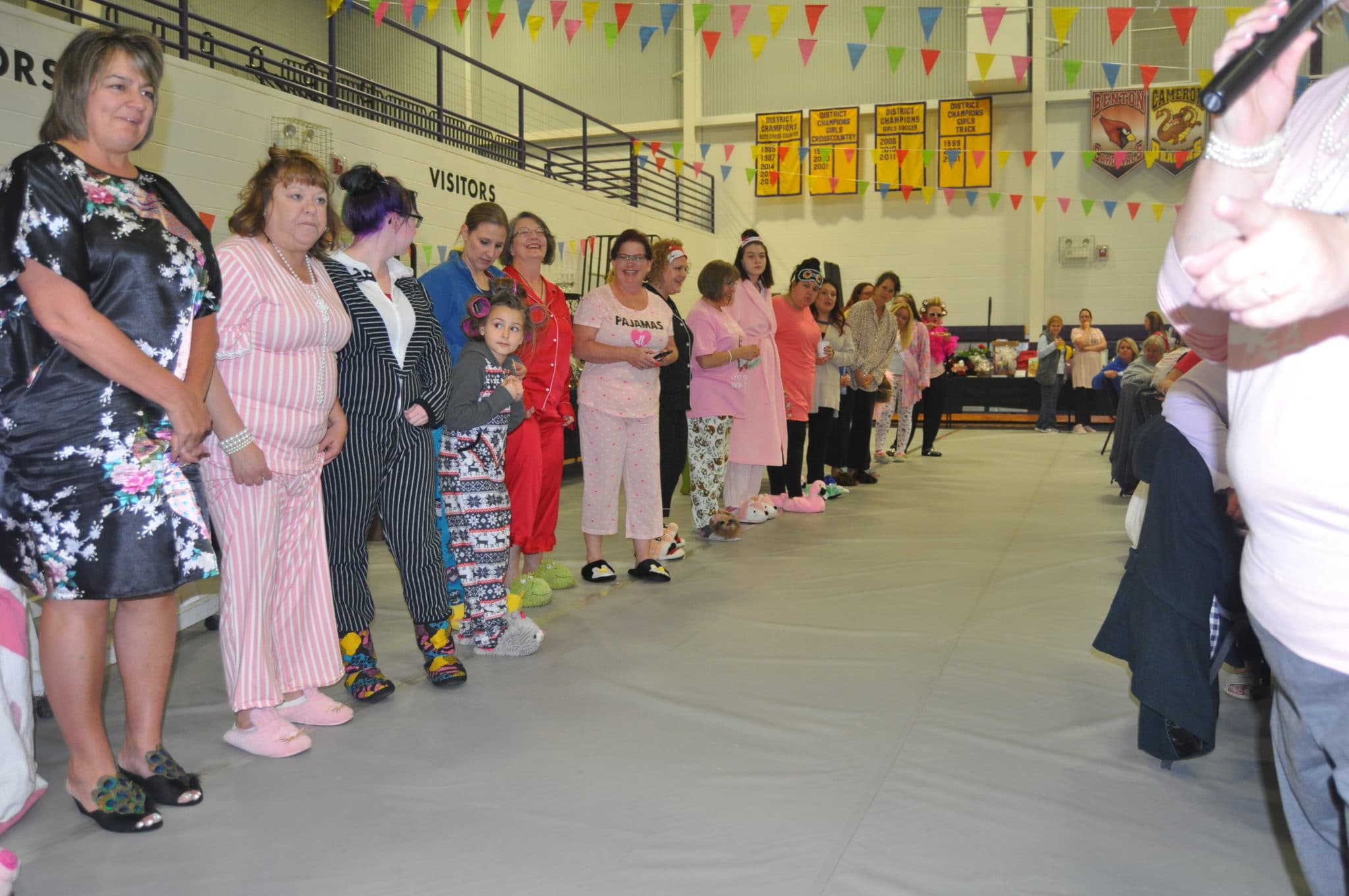 A group of people wearing pajamas form two lines and a tunnel