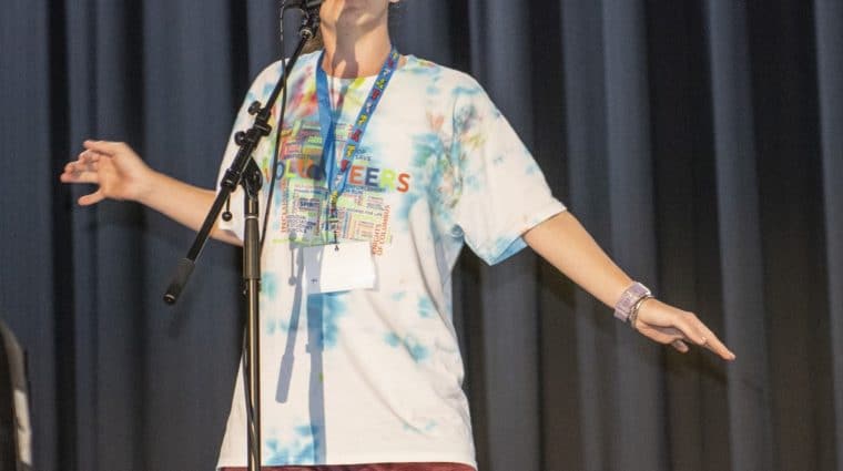 An athlete sings on a stage during a talent show