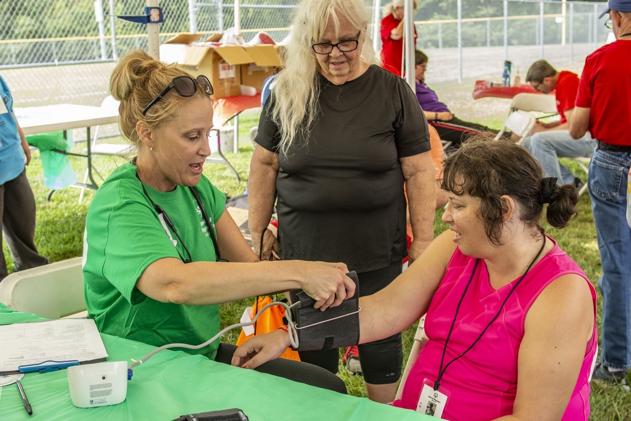 A health professional measures an athlete's blood pressure