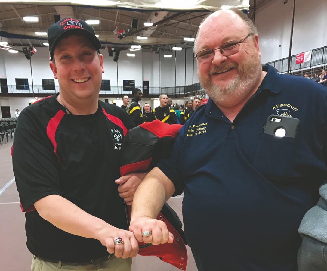Athlete and Knights of Columbus member pose together and show off their rings
