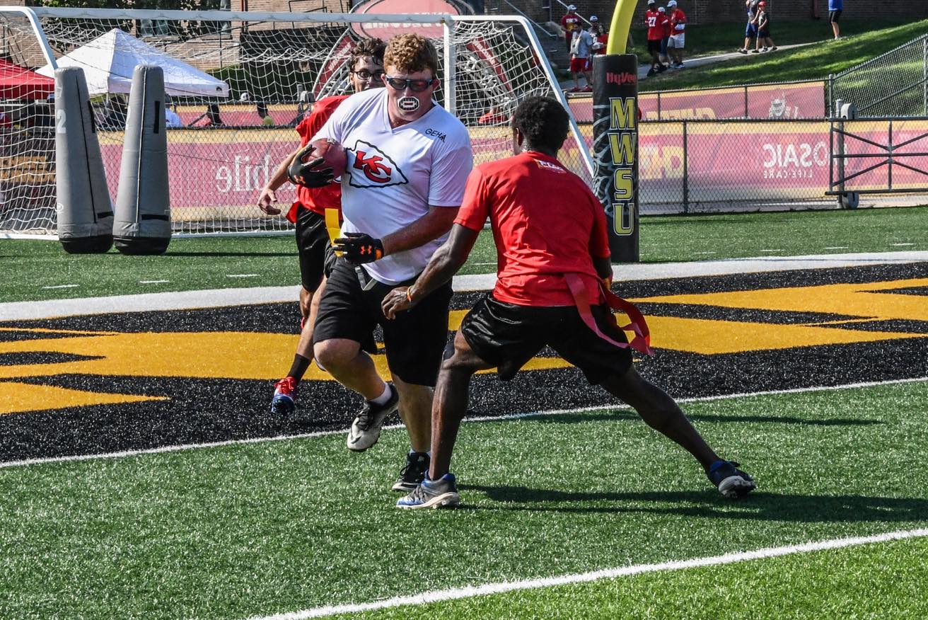 Special Olympics Missouri athlete TJ Bray runs past a defender at Chiefs Training Camp on Thursday, August 4, 2022.