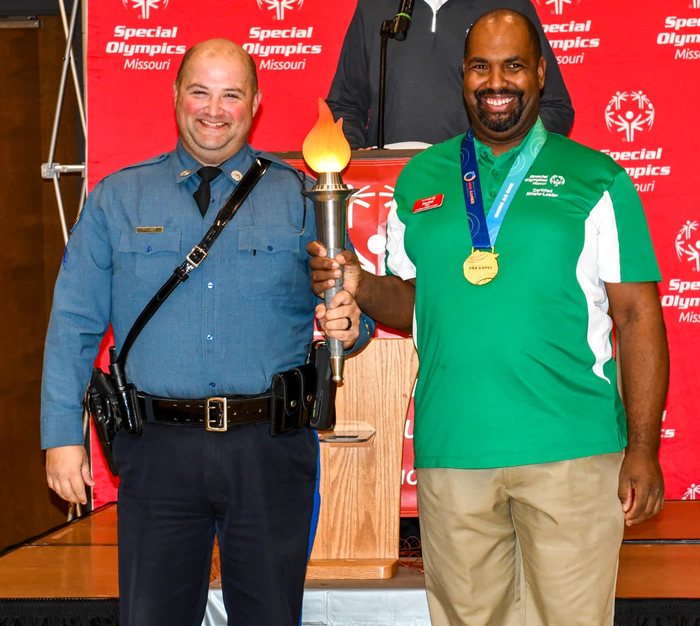 Joe Peart and Daxton Miller carry the Flame of Hope at the conclusion of the 2022 Law Enforcement Torch Run Celebration Lunch on Friday, Dec. 9, 2022 at the Training for Life Campus.