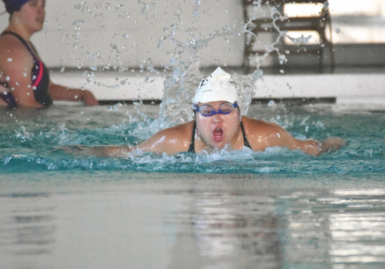 Byrd, Allison Swimming (Copy) A swimmer bursts out of the water gasping for breath as water splashes behind them