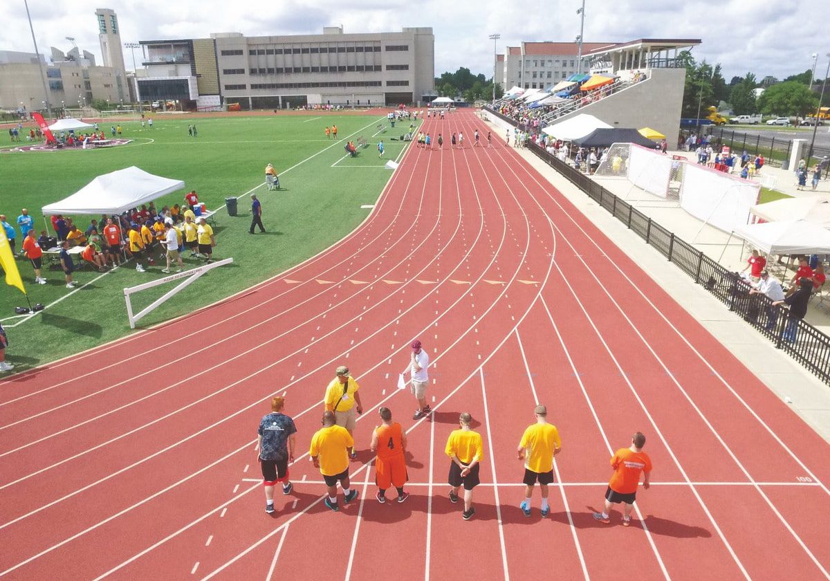 Aerial photo of the back of athletes on a track getting ready to race