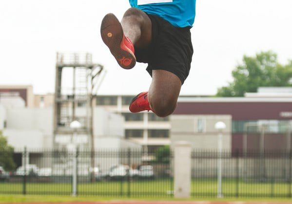 An athlete soars through the air during a long jump competition