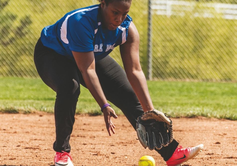 An athlete from Park Hill fields a softball moving from their right to left