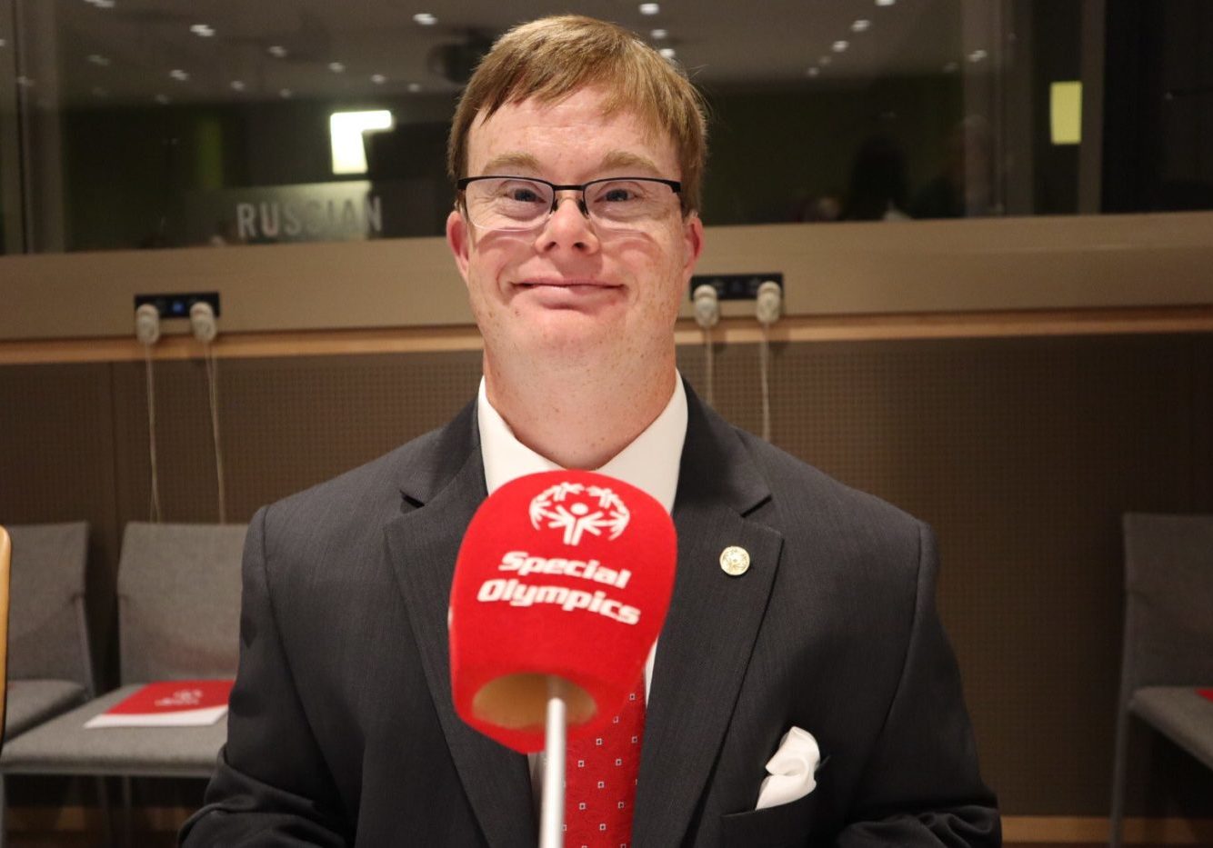 Athlete smiles at camera with a red microphone in front of them