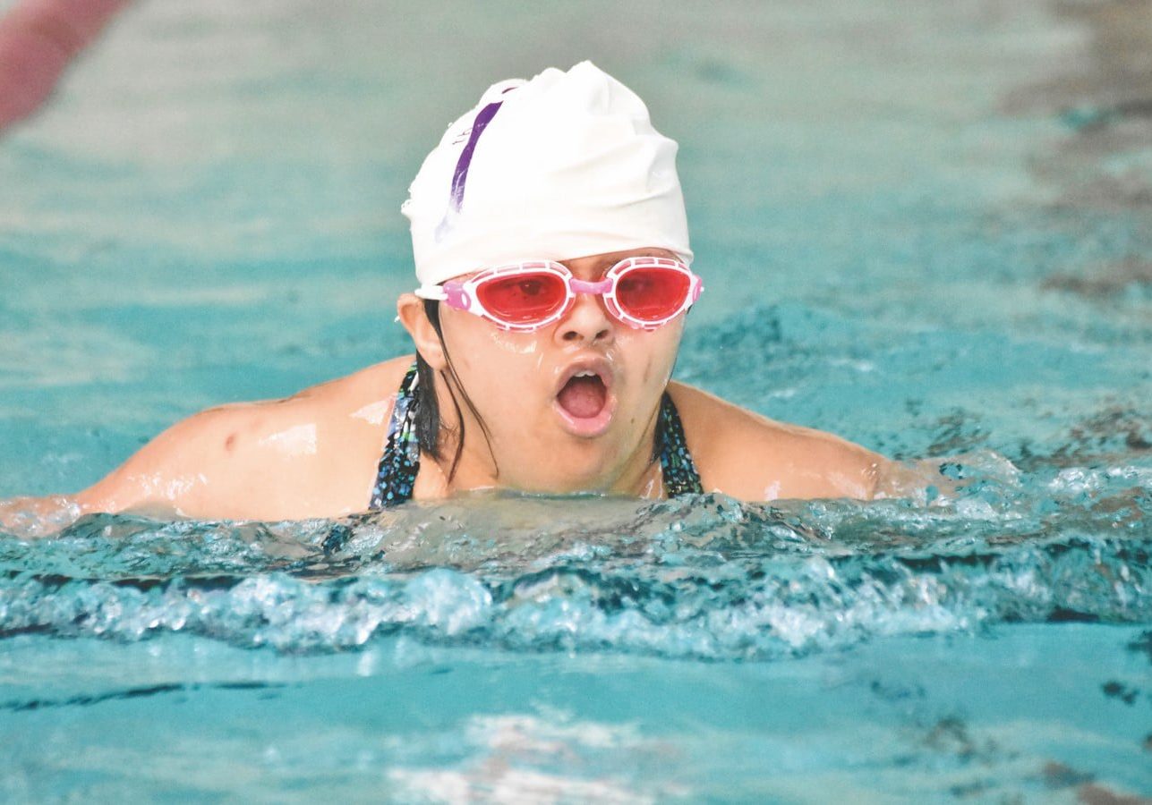 Naik, Neha Swimming (Copy) A swimmer with rose-colored goggles comes out of the water to take a large breath