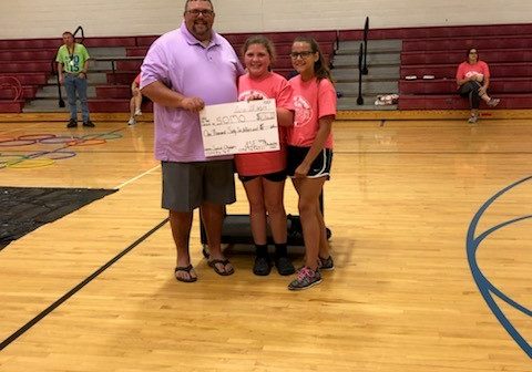 SOMO staff poses with students and holds up a big check